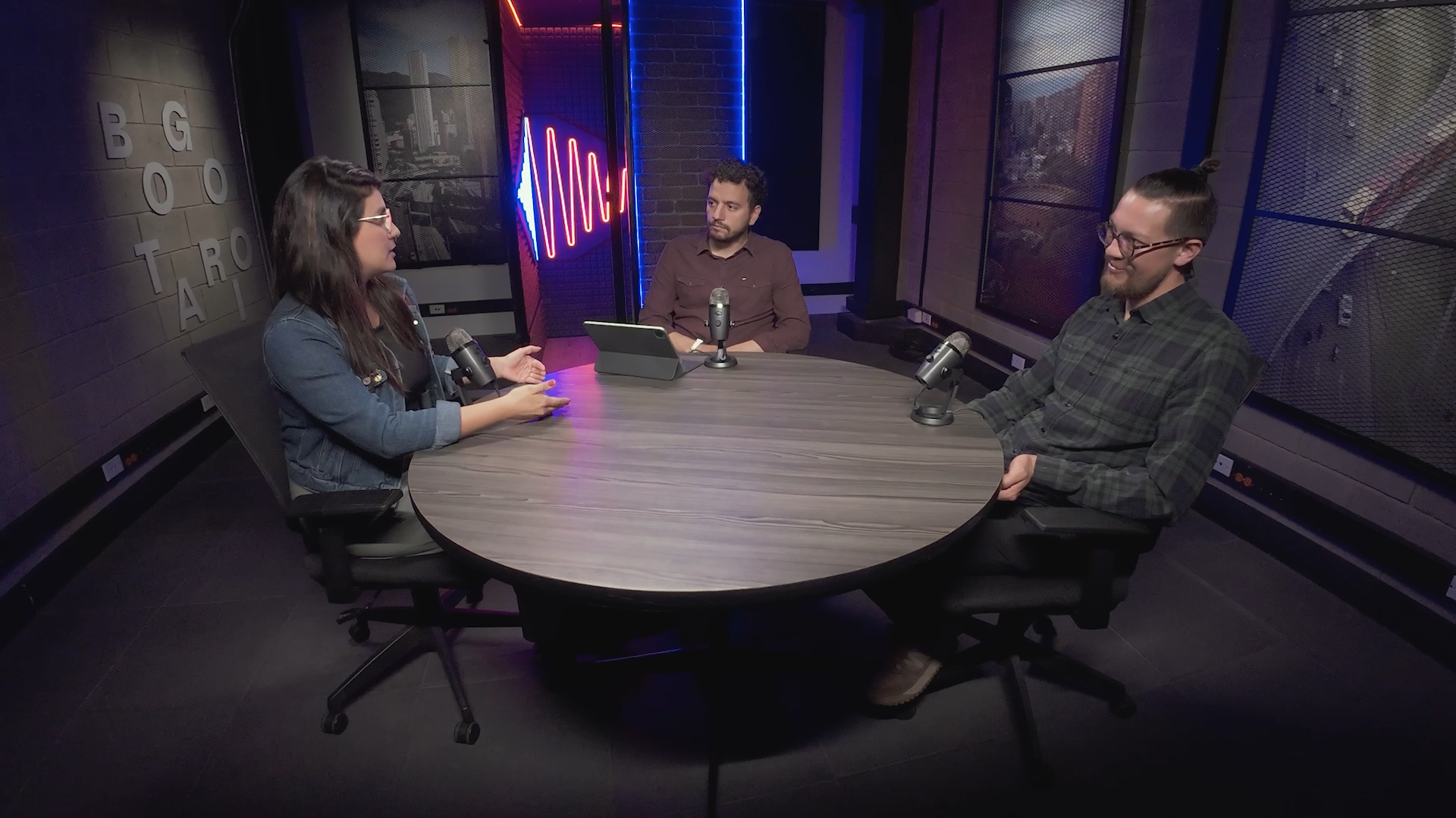Tres personas hablando sentadas alrededor de una mesa