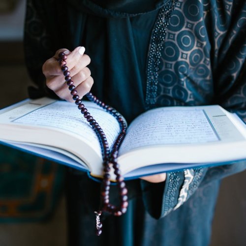 Biblia con rosario sostenidas por unas manos de mujer 