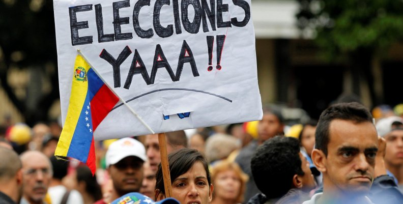 A demonstrator carries a sign that that reads "Elections right now" during a rally against Venezuela's President Nicolas Maduro in Caracas A demonstrator carries a sign that that reads "Elections right now" during a rally against Venezuela's President Nicolas Maduro in Caracas
