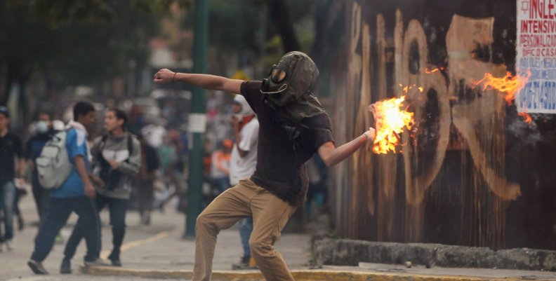 A demonstrator throws a molotov cocktail during clashes with riot police while rallying against Venezuela's President Nicolas Maduro in Caracas A demonstrator throws a molotov cocktail during clashes with riot police while rallying against Venezuela's President Nicolas Maduro in Caracas