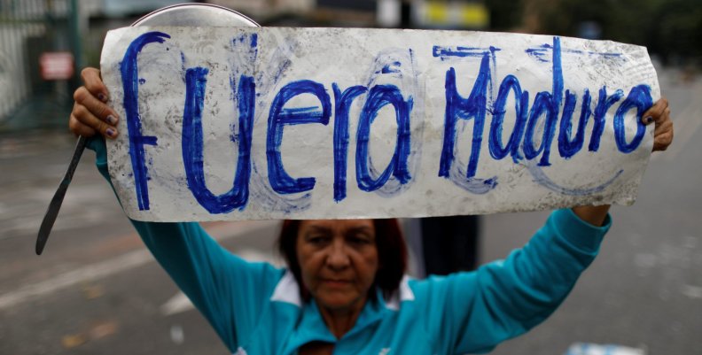 An opposition supporter holds a placard that reads "Maduro out" as she attends a rally against Venezuela's President Maduro in Caracas An opposition supporter holds a placard that reads "Maduro out" as she attends a rally against Venezuela's President Maduro in Caracas