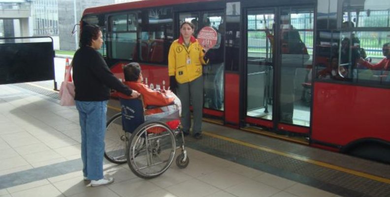 TransMilenio Persona en silla de ruedas subiéndose a un bus rojo de TransMilenio