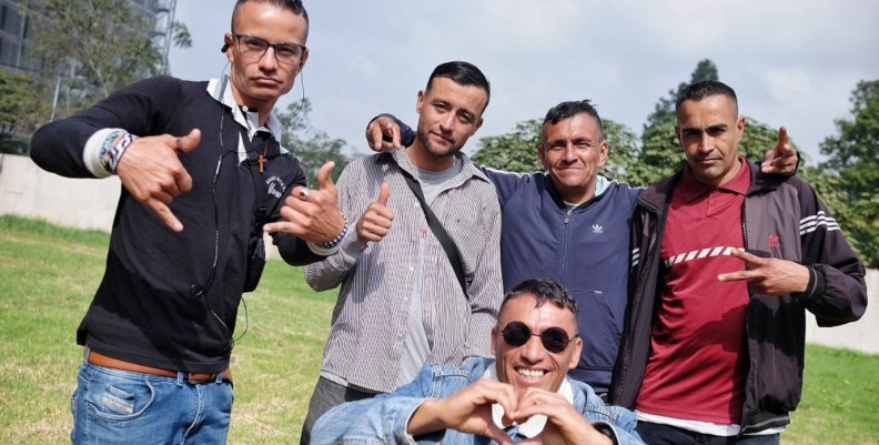 Habitantes de calle Cinco hombres posando sonrientes