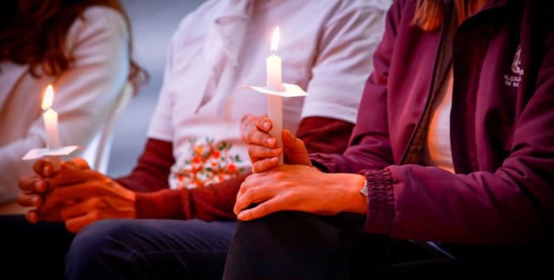 Feminicidio Tres personas, cada una sosteniendo una vela encendida en sus manos