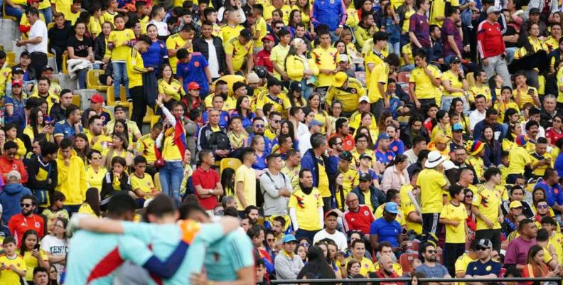 Tribuna del estadio El Campín con aficionados con camisetas amarillas
