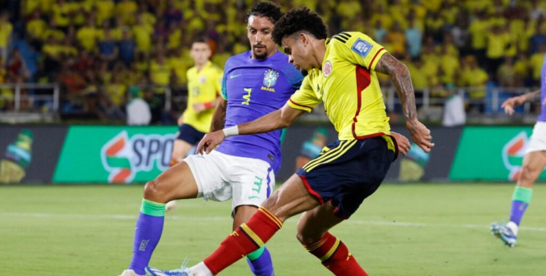Selección Colombia Dos jugadores disputando un balón: uno con uniforme amarillo y el otro azul