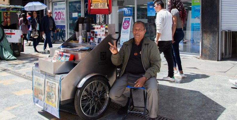 Un café con fe Un hombre al lado de un carro metálico