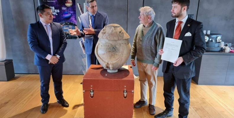 Funcionarios de la Cancillería recibiendo un jarrón de la cultura Quimbaya