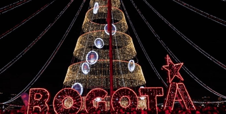 Navidad Árbol de Navidad iluminado detrás de un letrero que dice "Bogotá"
