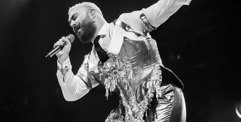 Sam Smith Cantante en una tarima vestido con traje