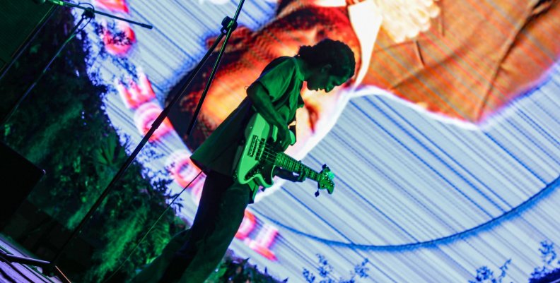 Estéreo Picnic Músico con una guitarra sobre una tarima
