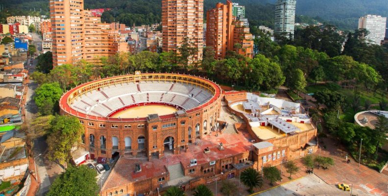 Localidad de Santa Fe Plaza de toros color ladrillo. Atrás hay unas torres de apartamentos