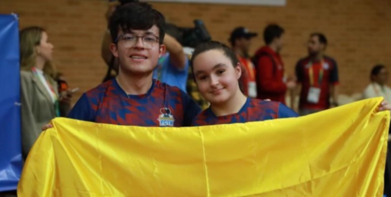 Dos deportistas sosteniendo la bandera amarilla, roja y azul de Colombia Julián Andrés Chinchilla y Jessica Alzate tras ganar la medalla de oro | IDRD