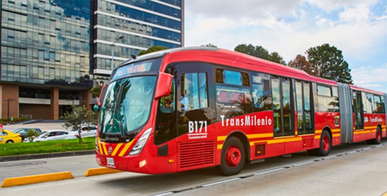 Bus de TransMilenio, color rojo, rodando por la calle 
