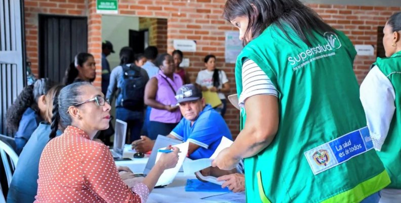 Subred Centro Oriente Mujer con chaleco verde hablando con otra mujer sentada en una mesa