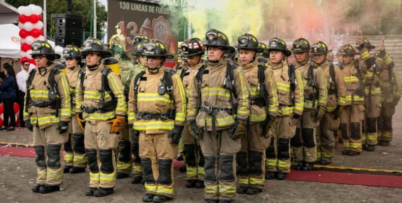 Bomberos de Bogotá Una fila de hombres en marcha con uniformes de bombero