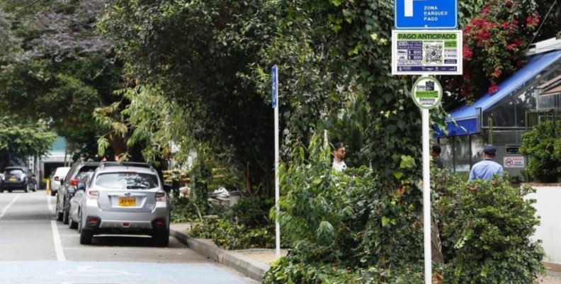 Zonas de parque pago Una carretera con espacios para parquear carros