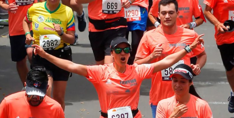 Media Maratón de Bogotá Personas con camisetas naranja corriendo