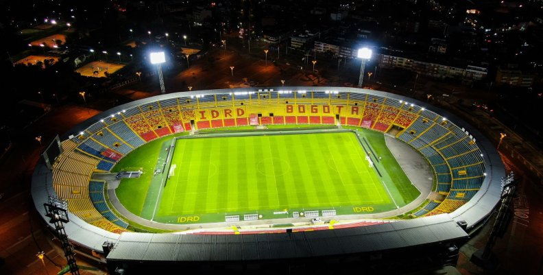 Final Liga Betplay Vista panorámica de un estadio con gradas rojas y amarillas y césped verde en el medio