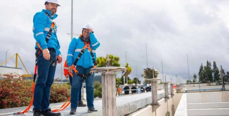 Agua de Bogotá Un hombre y una mujer con chaquetas azules y cascos blancos
