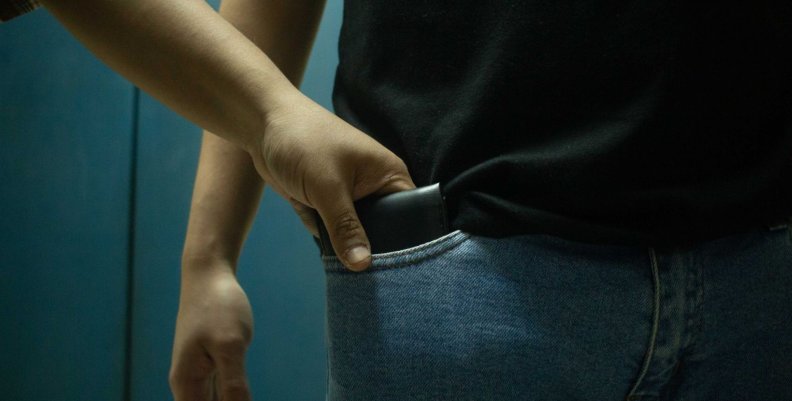 Cosquilleo Hombre sacando un celular del bolsillo de otro