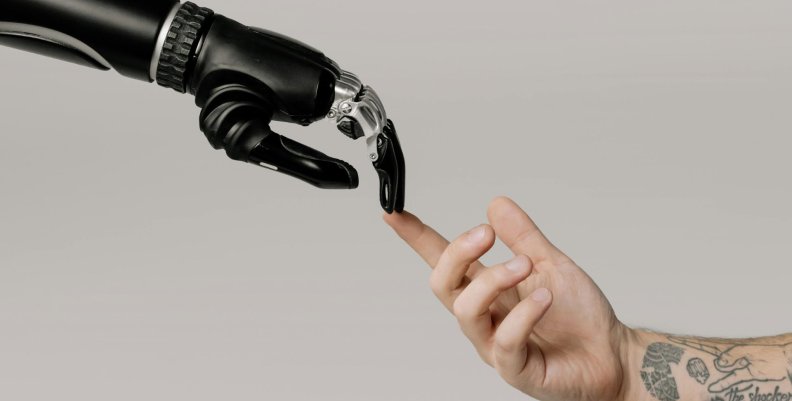 Inteligencia artificial Una mano humana tocando con el dedo índice a una mano robótica.
