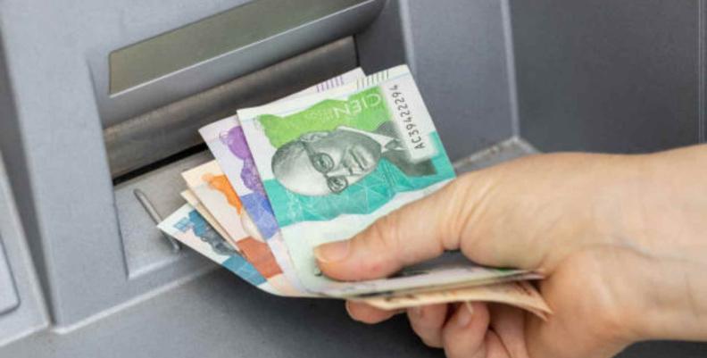 Persona retirando dinero de un cajero Dinero siendo retirado de un cajero automático