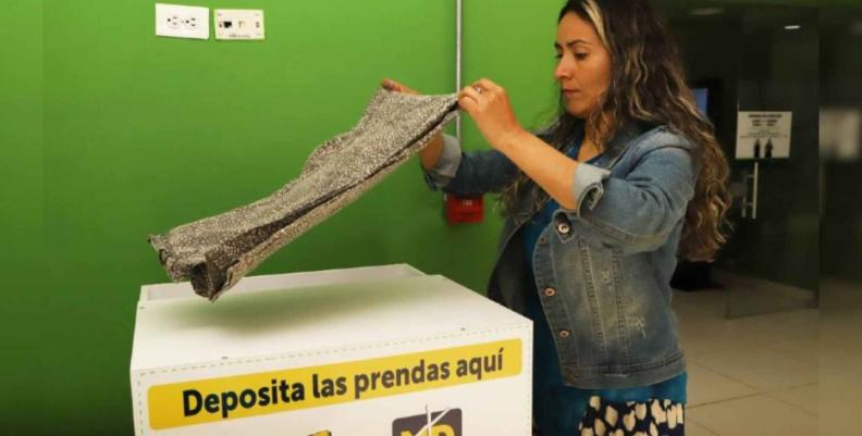 Mujer depositando ropa usada en uno de los contenedores habilitados por la Alcaldía 