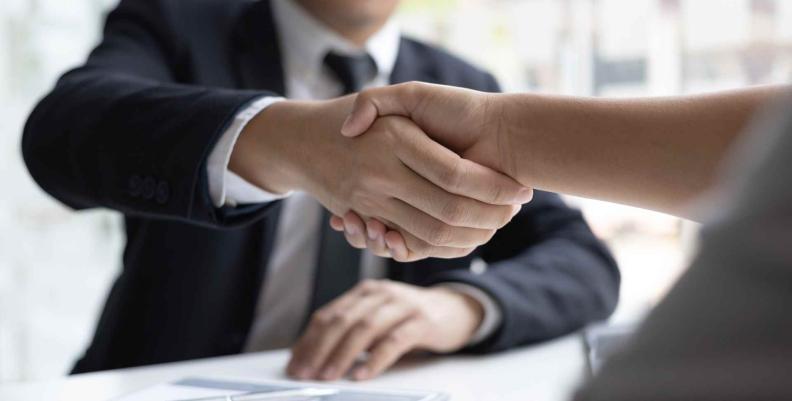 Señal de de trato con dos hombres apretando sus manos Hombres apretando su mano en señal de trato