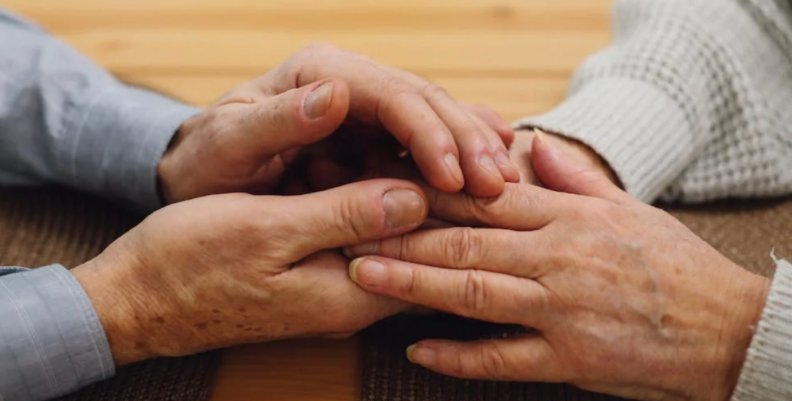 Las manos entrelazadas de dos personas mayores
