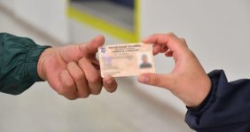 Una mano recibiendo una carnet de otra