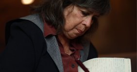 Una mujer de cabello negro firmando un libro