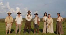 Cuatro hombres y tres mujeres vestidos con ropa antigua del campo