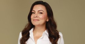 Una mujer sonriente con camisa blanca
