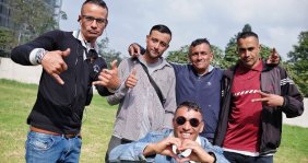 Cinco hombres posando sonrientes