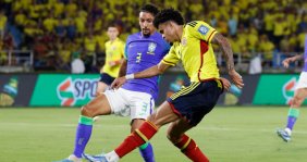 Dos jugadores disputando un balón: uno con uniforme amarillo y el otro azul