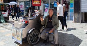 Un hombre al lado de un carro metálico