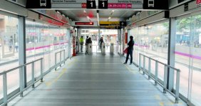 Estación de transMilenio por dentro un pacillo con piso metálico y puertas de cristal a los lados
