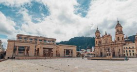 Una catedral al lado de un edificio de congreso en medio de una plaza