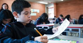 Niño con una hoja y un lápiz en la mano 