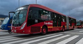 Bus rojo de TransMilenio sobre la calle