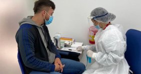 Enfermera vacunando a un joven 