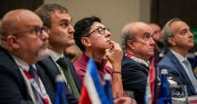 Cinco hombres sentados mirando fijamente hacia el frente