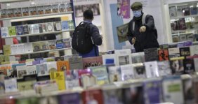 Dos personas caminando por pasillos llenos de libros