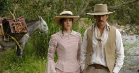 Un hombre y una mujer, vestidos con ropa blanca antigua. Atrás hay un caballo
