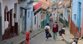 Una calle con casas a los lados y personas caminando 