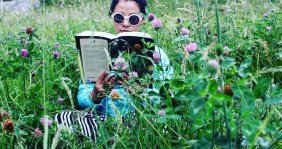 Lala Ocampo leyendo en medio de plantas 
