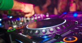 Una mano manipulando un mesa de mezclas de DJ
