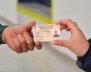 Una mano recibiendo una carnet de otra