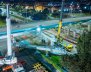 Un puente vehicular de concreto, rodeado de maquinaría de obra